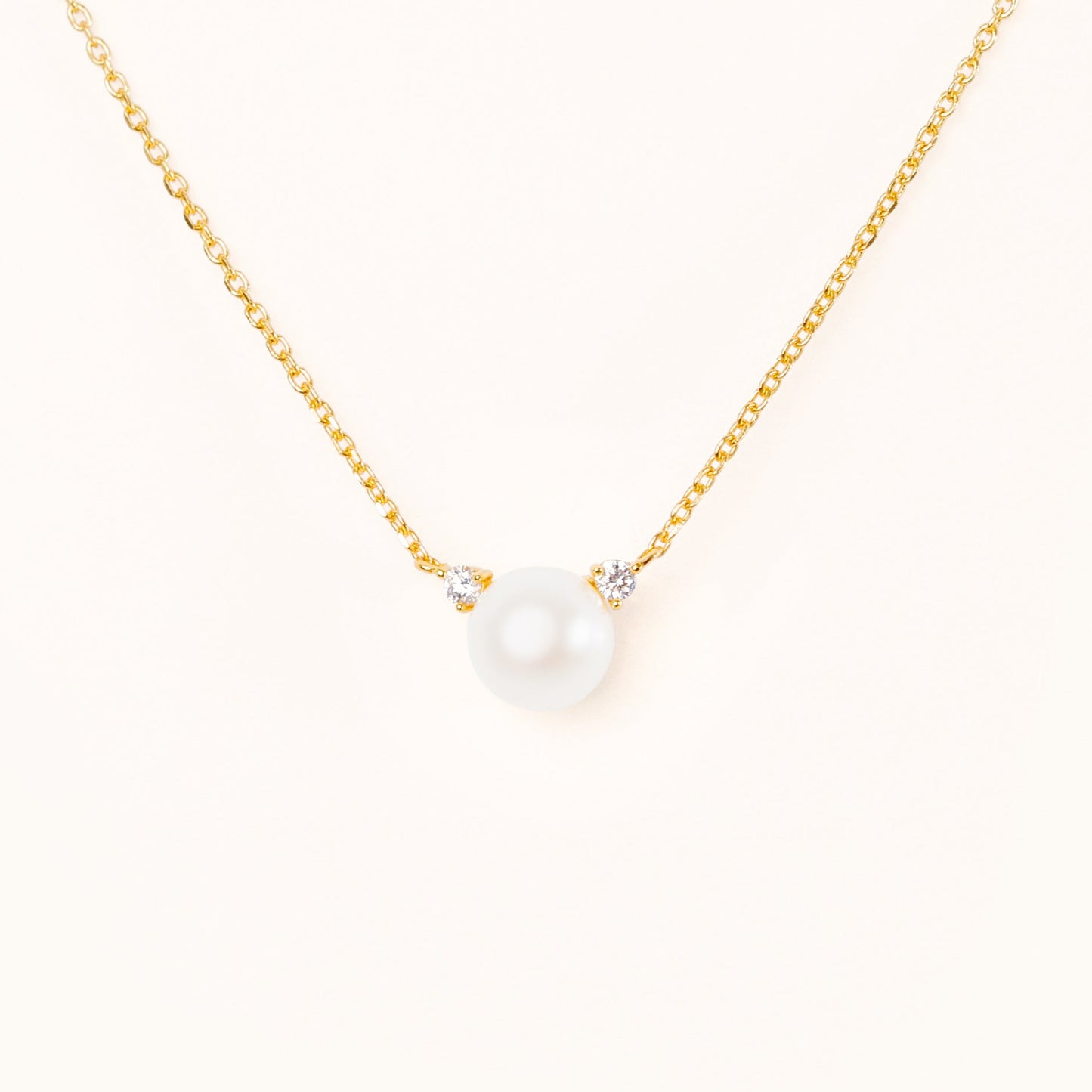 Pearl with two beautiful diamond accents, connecting to an adjustable gold chain