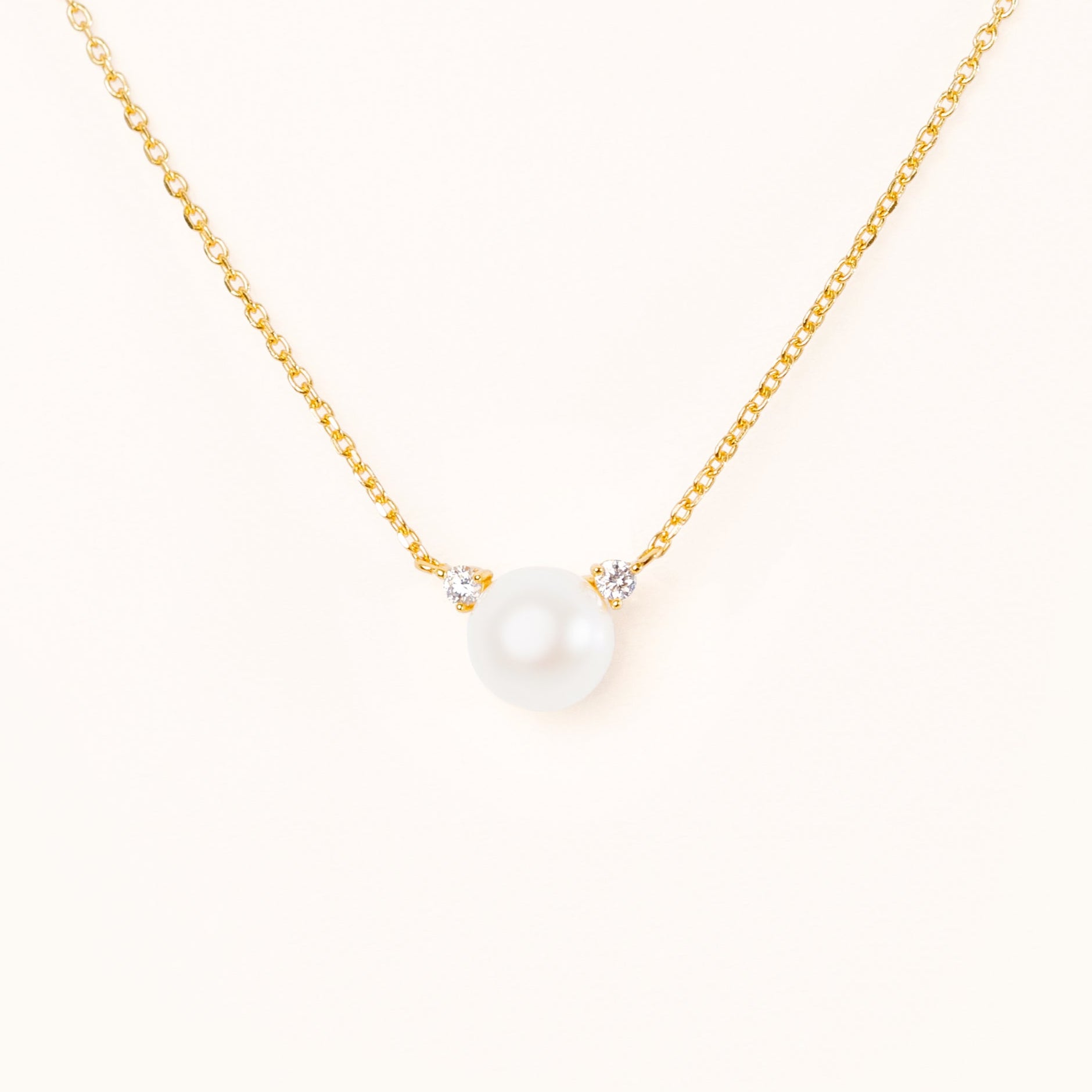 Pearl with two beautiful diamond accents, connecting to an adjustable gold chain