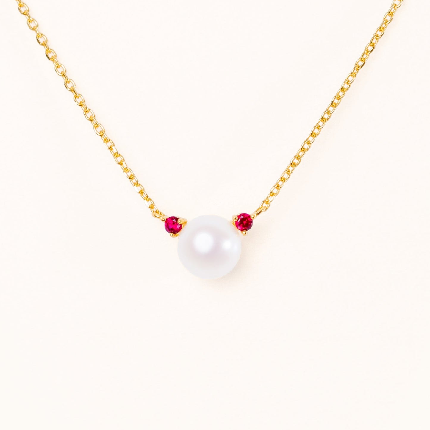 Pearl with two beautiful red ruby accents, connecting to an adjustable gold chain