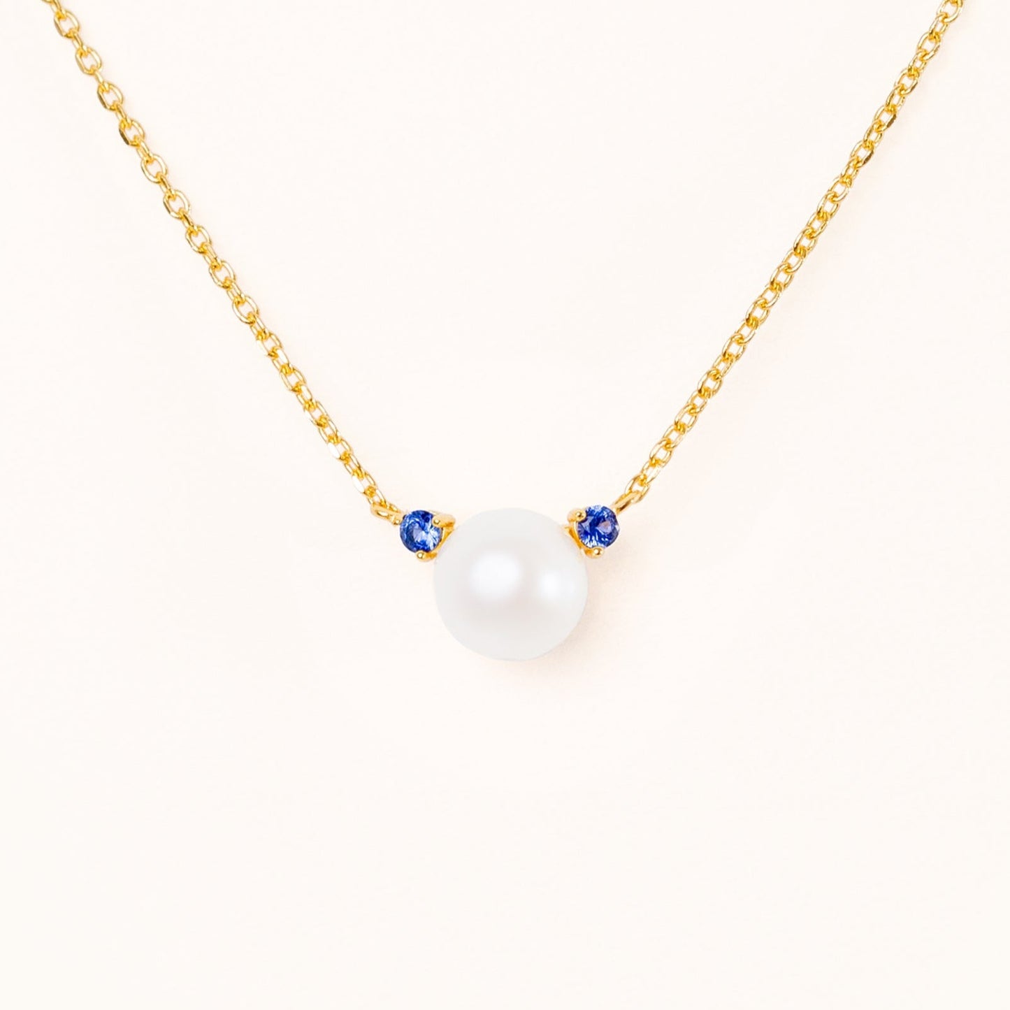 Pearl with two beautiful blue sapphire accents, connecting to an adjustable gold chain