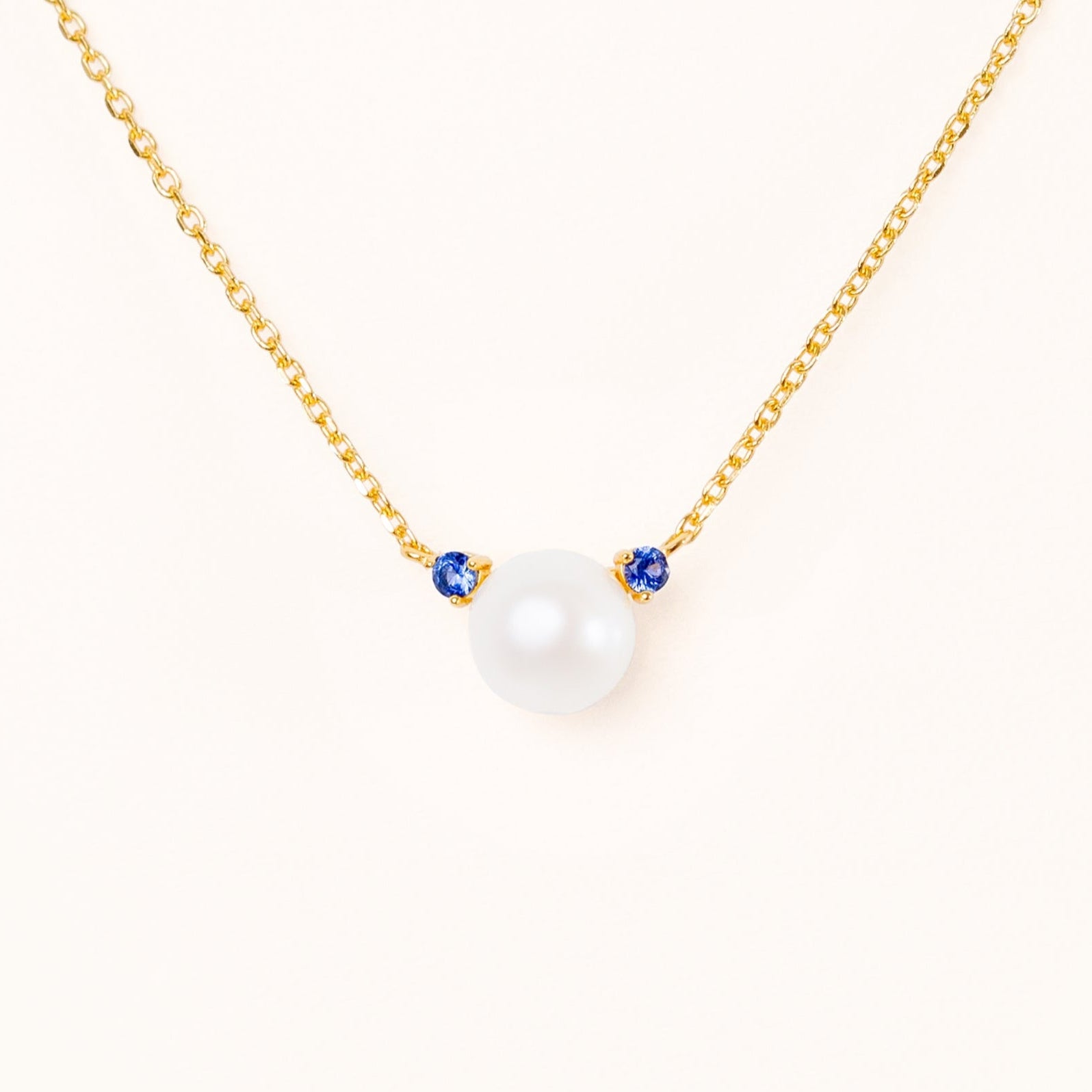 Pearl with two beautiful blue sapphire accents, connecting to an adjustable gold chain