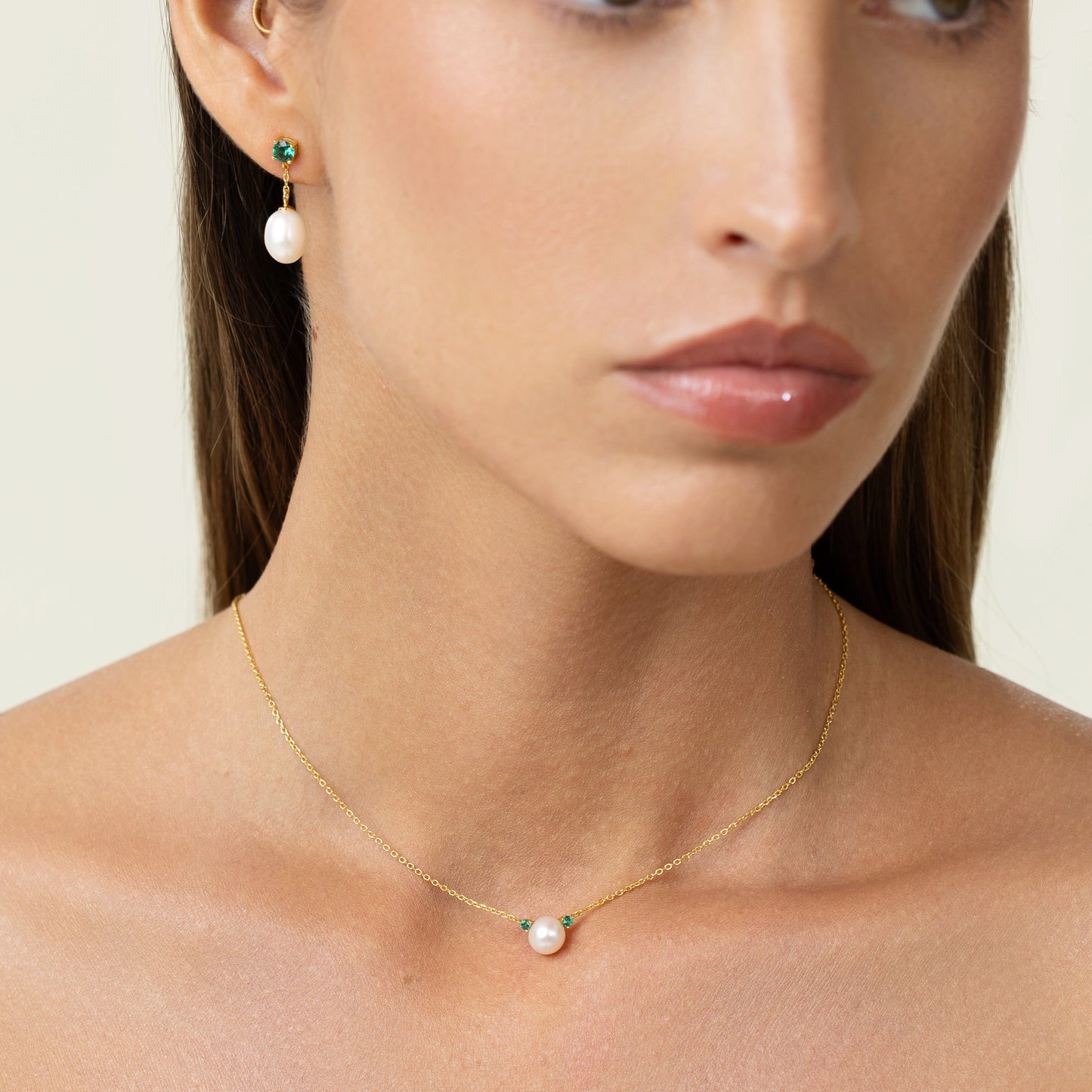 pearl necklace with emeralds and gold chain.