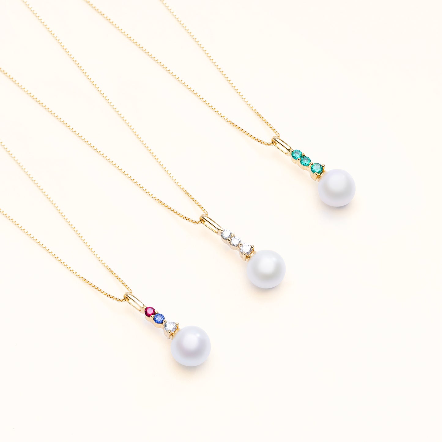 The aurora pearl pendant collection, with options of 3 diamonds, emeralds, or a mix of ruby, sapphire, and diamond