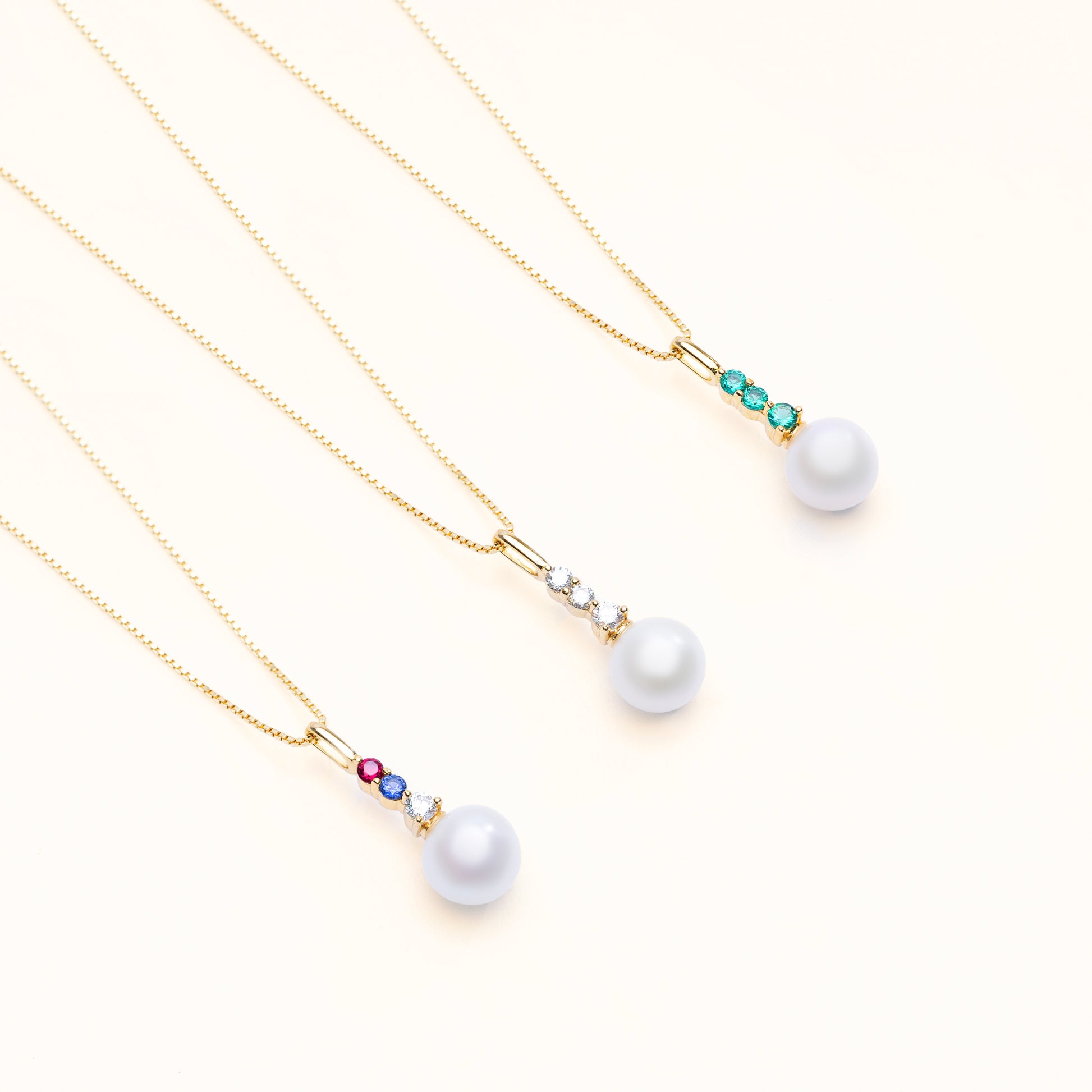 The aurora pearl pendant collection, with options of 3 diamonds, emeralds, or a mix of ruby, sapphire, and diamond