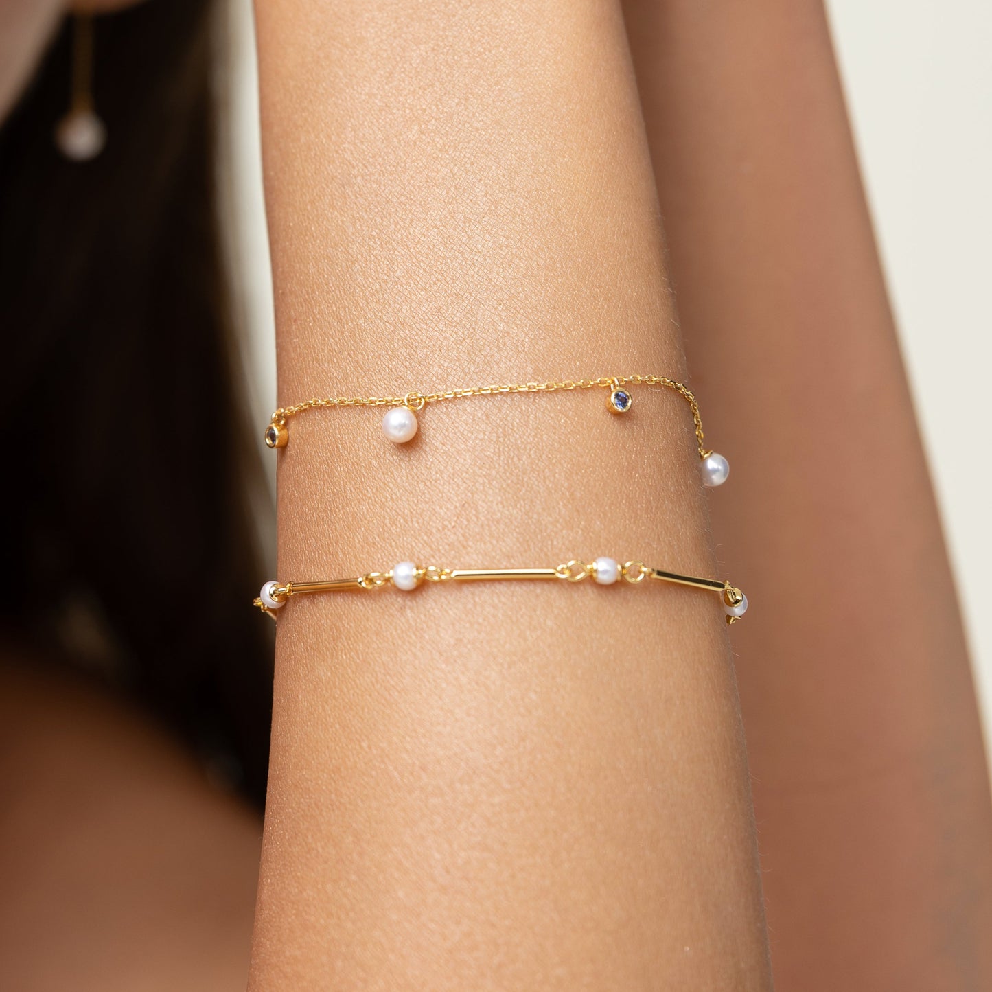 Pearl bracelet on a gold chain with dainty sapphire charms