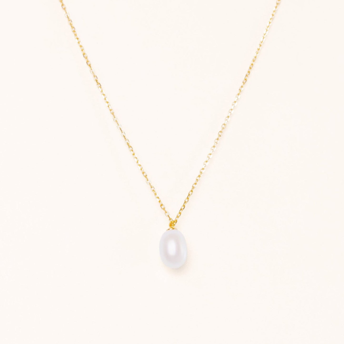 Simple elegant necklace with a teardrop pearl hanging from a gold chain