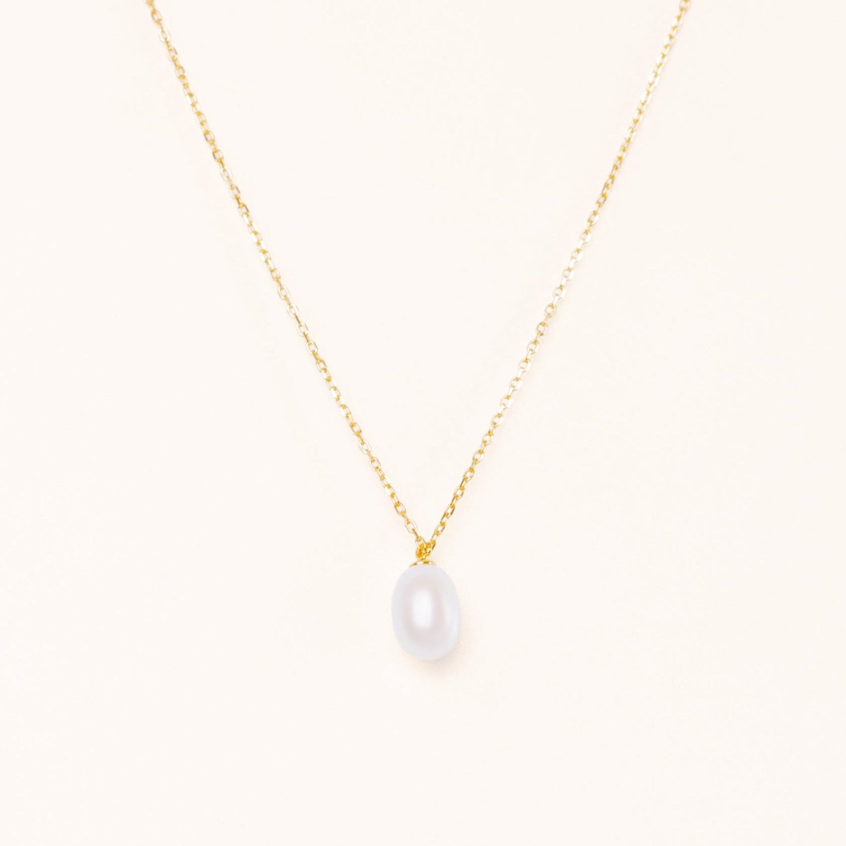 Simple elegant necklace with a teardrop pearl hanging from a gold chain