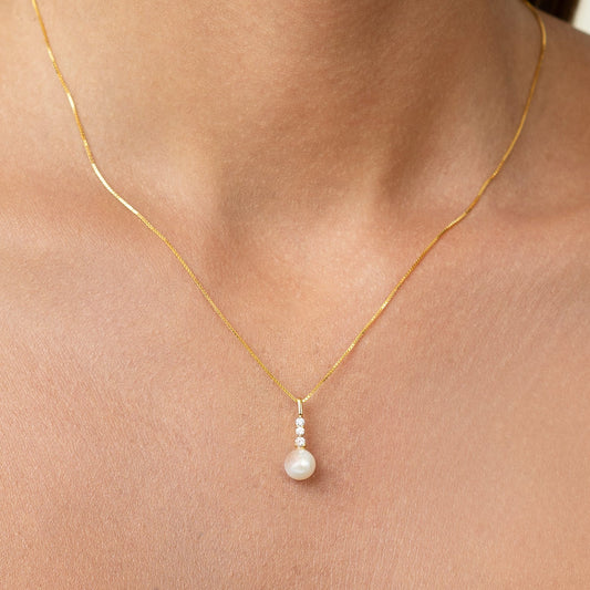 Diamond necklace with 3 diamonds. On a sleek gold adjustable chain, with a beautiful pearl