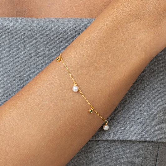 Pearl bracelet on a gold chain with dainty emerald charms