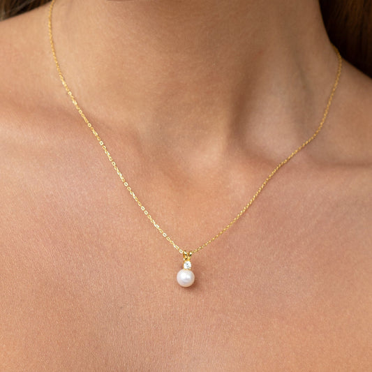 Pearl pendant with a large diamond and an adjustable gold chain.