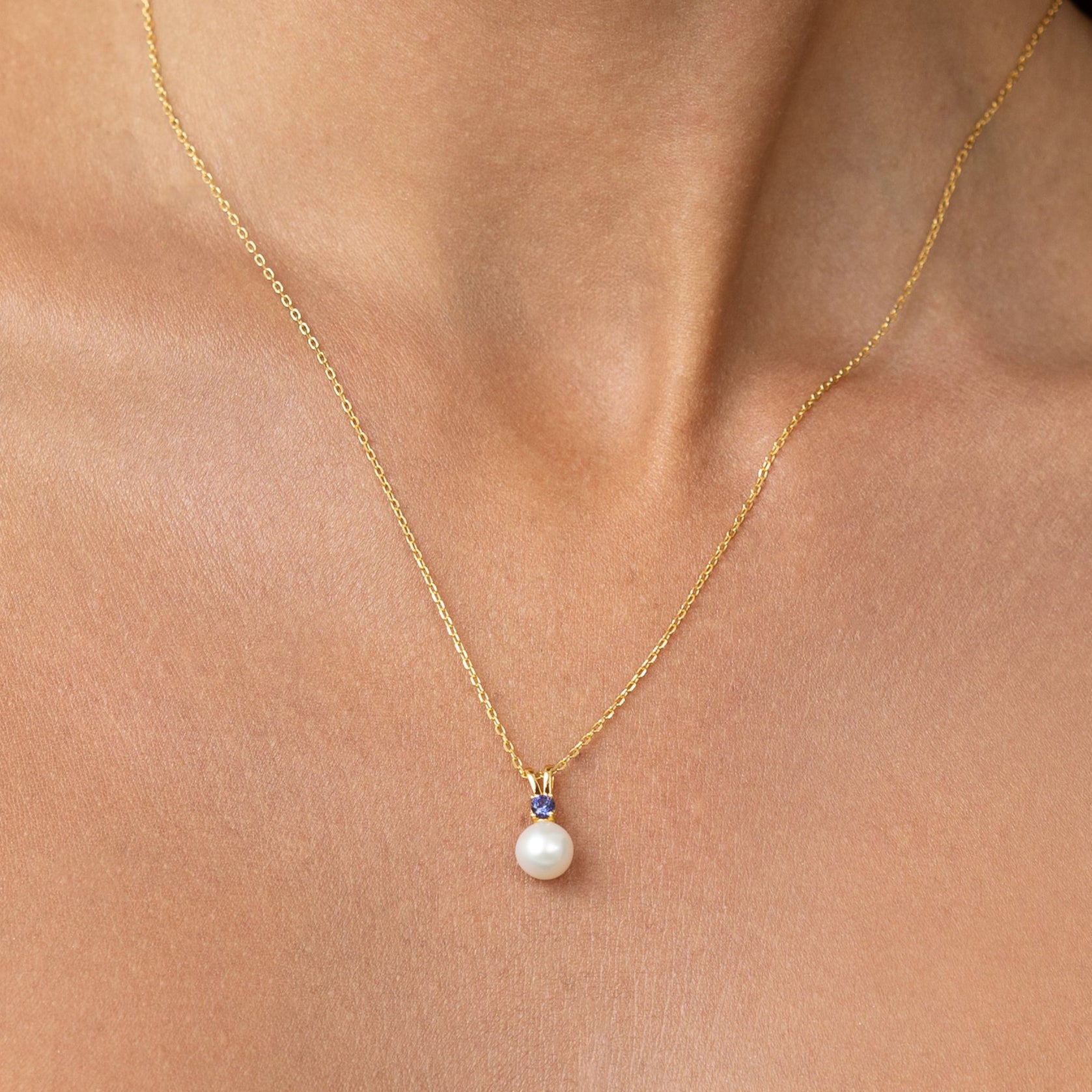 Pearl pendant with a large blue sapphire.
