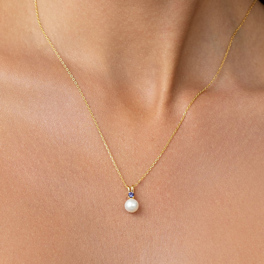 Pearl pendant with a large blue sapphire.