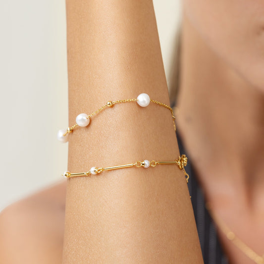 Pearl bracelet with gold beads on a gold chain. Stacked with the gold bar bracelet.