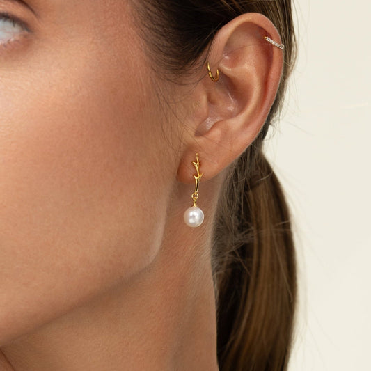 Drop earrings showcasing round freshwater pearls suspended from branch-like 18k gold-plated 925 silver hooks