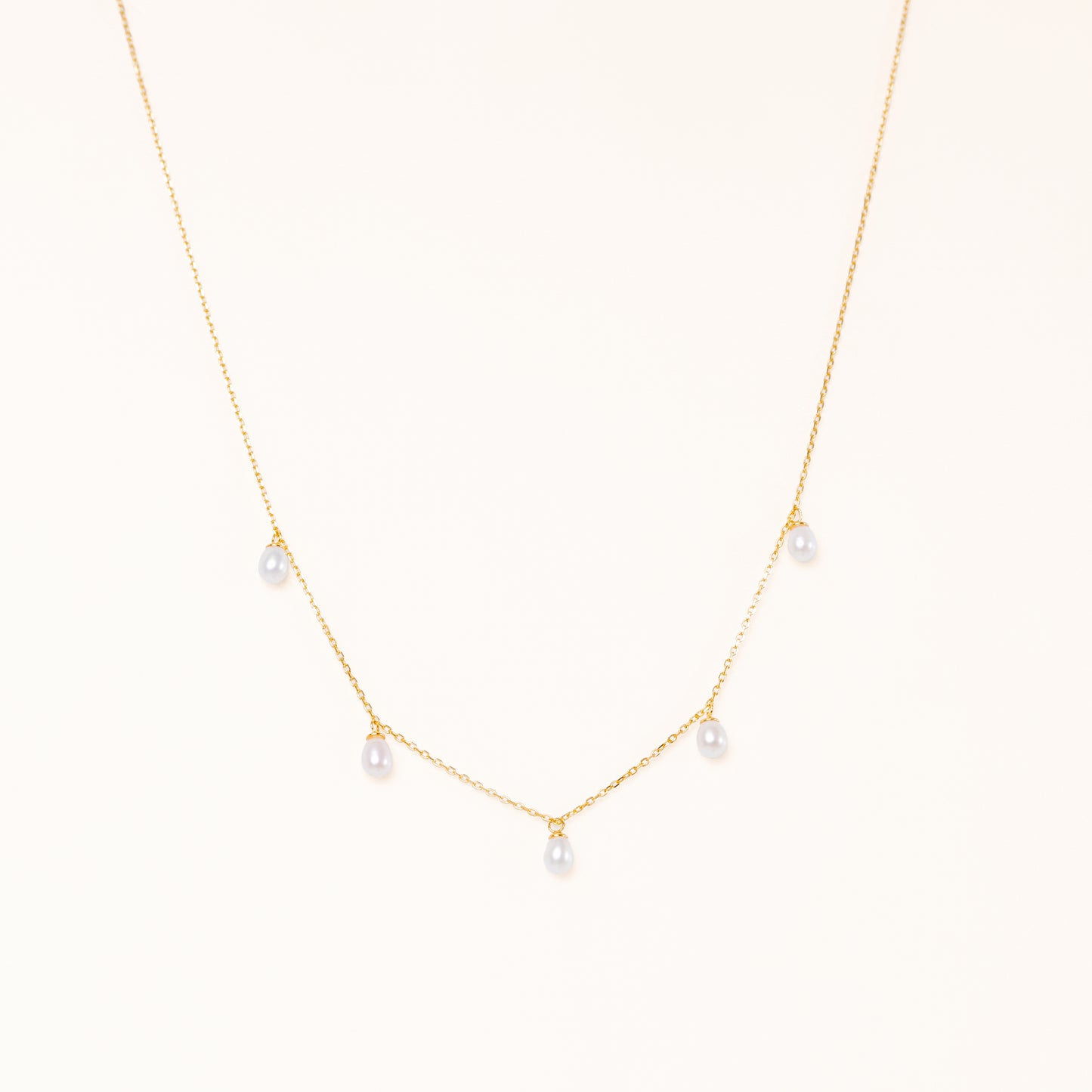 Tear shaped pearls dangling from a gold chain
