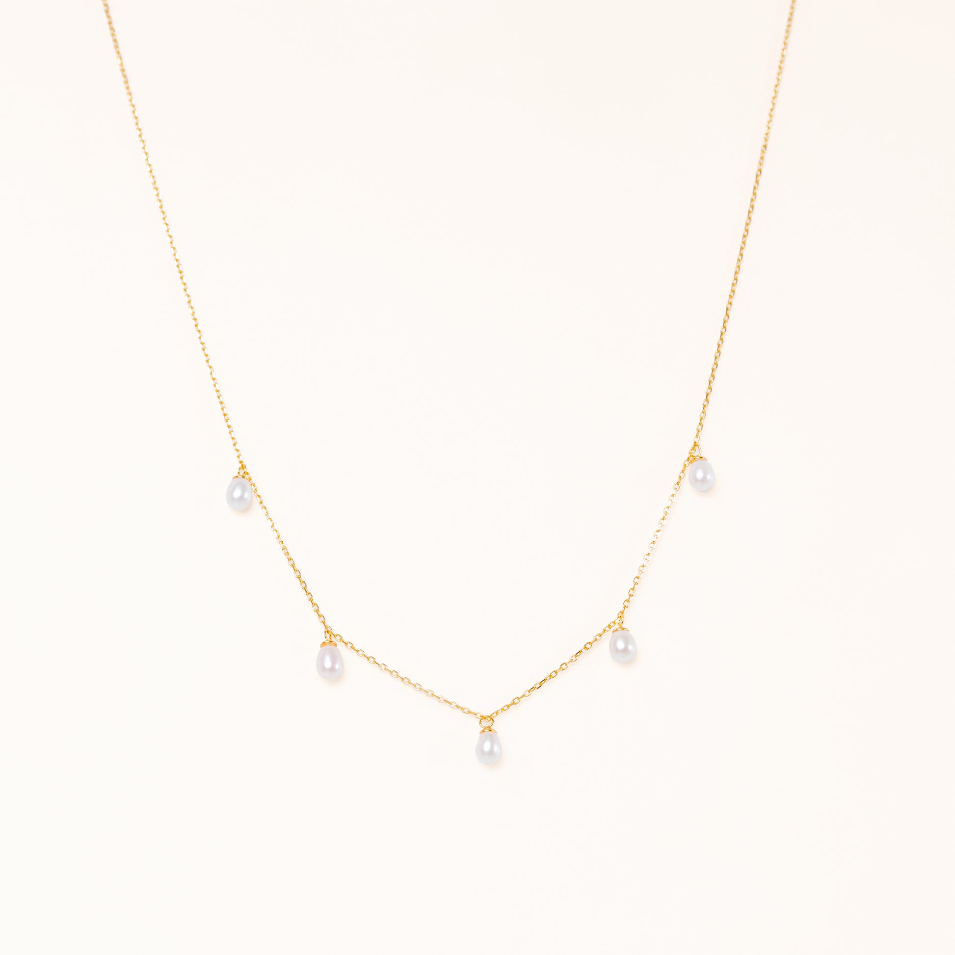 Tear shaped pearls dangling from a gold chain