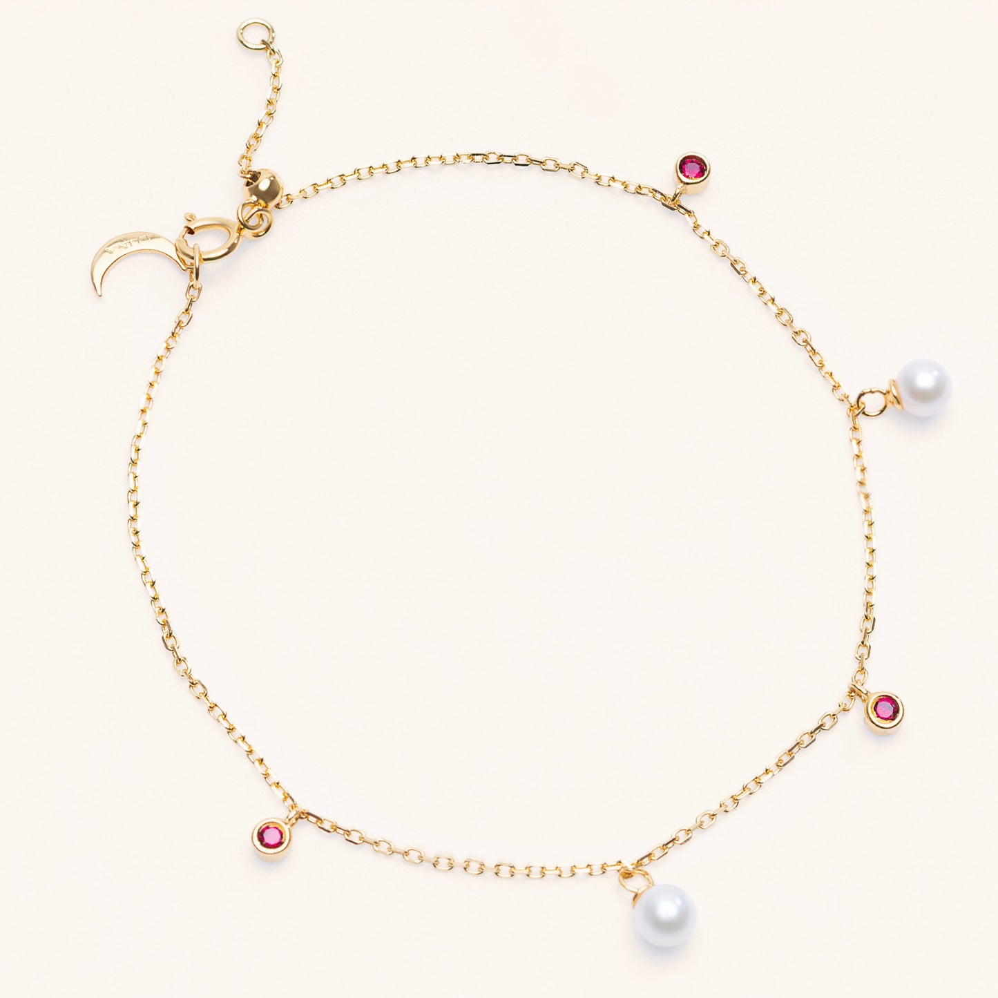 Pearl Luna Bracelet with an adjustable sliding clasp. With small round pearls and ruby charms