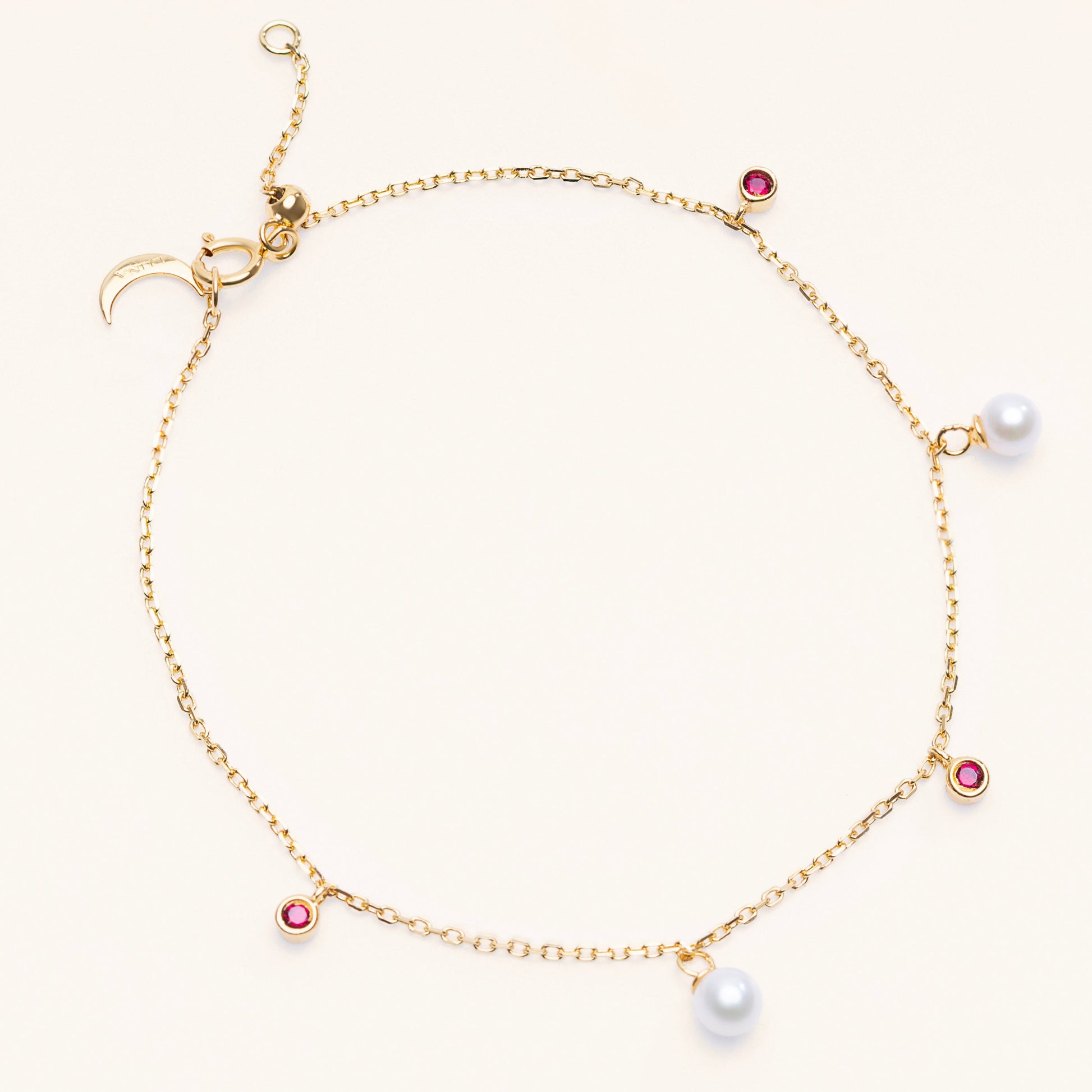 Pearl Luna Bracelet with an adjustable sliding clasp. With small round pearls and ruby charms