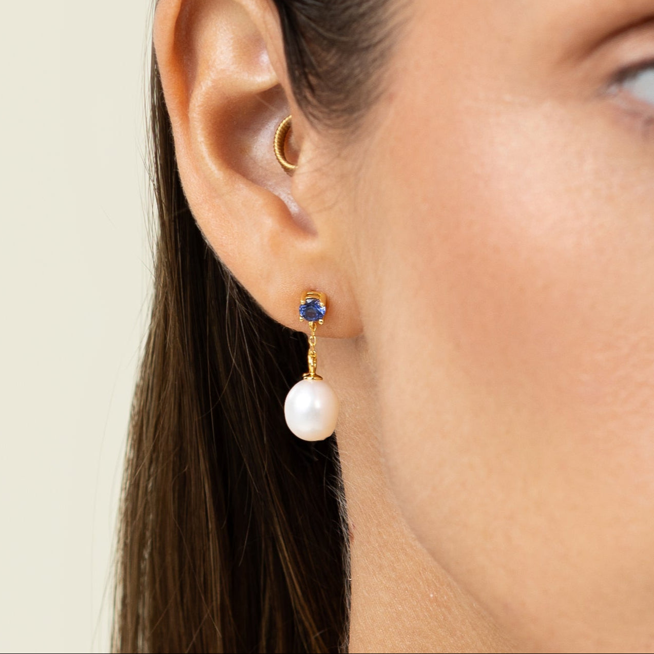 Drop earring featuring a round lab-grown sapphire stud and an oval freshwater pearl on 18k gold-plated 925 silver
