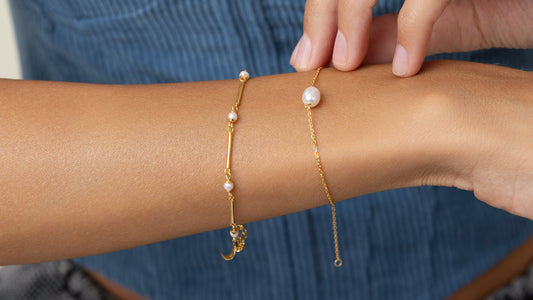 Simple pearl bracelet with a single pearl, stacked with the iconic gold bar bracelet.