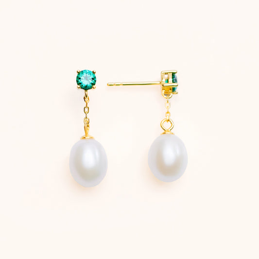 Beautiful pearls dangling from a large green emerald