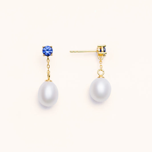 Beautiful pearls dangling from a large blue sapphire