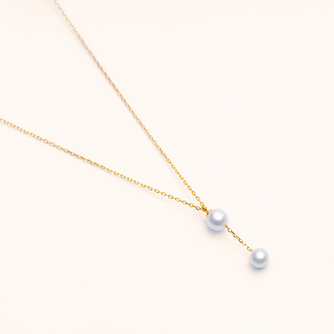 Close-up of a cascade freshwater pearl necklace with pearls layered on a delicate gold chain