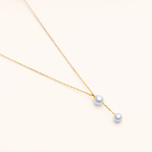 Close-up of a cascade freshwater pearl necklace with pearls layered on a delicate gold chain