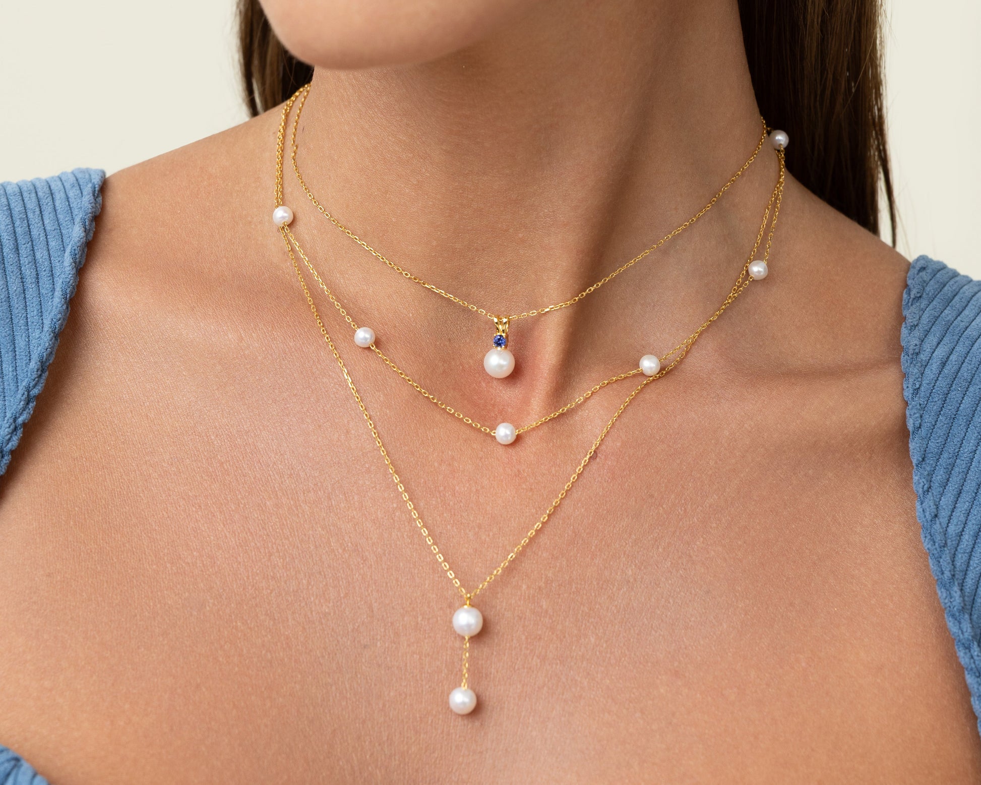 Large peal with a smaller pearl hanging by a gold chain. With a chain of round pearls. And the pearl halo pendant. Simple and elegant. Perfect for stacking.