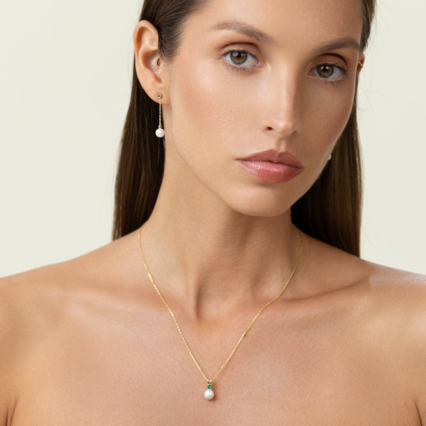 Drop earrings featuring two green lab-grown emerald accents and round freshwater pearls on 18k gold-plated 925 silver studs